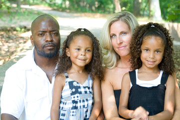 A loving mixed race family enjoying the park