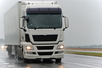 Obraz na płótnie Canvas biały samochód ciężarowy w czasie deszczu