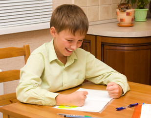 Smiling  boy doing his homework