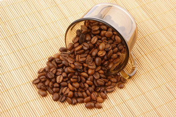Glass cup with coffee grains on wooden background