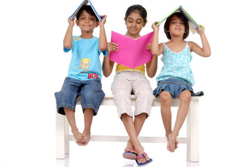 Obraz premium Brother and two sisters holding books