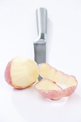 potatoes with knife against the white background