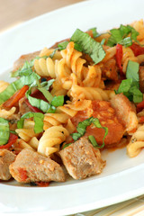 Pasta with baked tomato, meat and basil