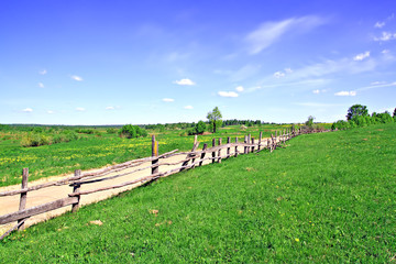 Fototapeta na wymiar old fence on field along road