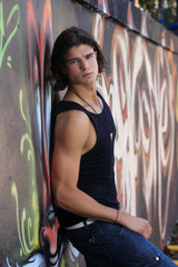 Fototapeta premium young man in front of graffitti wall