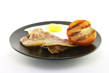 Bacon, Eggs and Tomato on a Black Plate