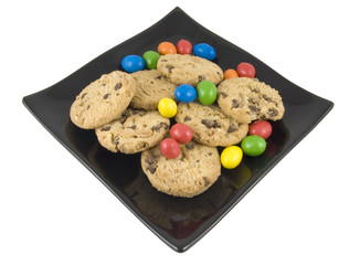 sweets and cookies on black plate isolated on white