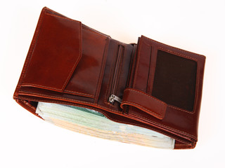 A brown wallet full of money isolated on a white background