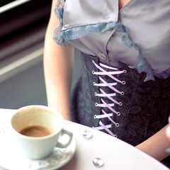 girl in a corset has breakfast in cafe, small depth of sharpness