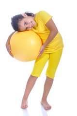 Little beautiful girl in yellow with yellow ball