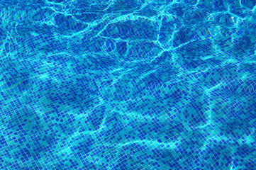 Blue clear water ripples of swimming pool with mosaic bottom