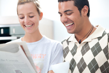 junges Paar liest gemeinsam Zeitung