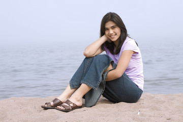 Young girl sitting on beach