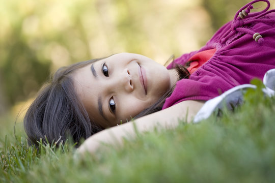 Little girl lying on grass - Powered by Adobe