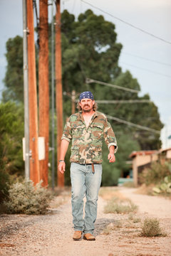 Man in camoflauge walking on dirt road