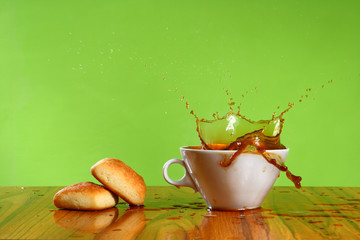 coffee splash on a green background in a white cup