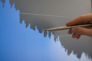 Businessman's hand showing diagram on financial report with pen