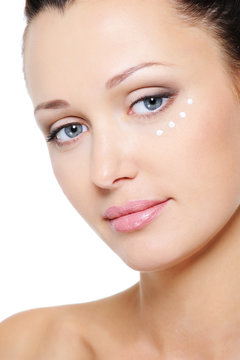 woman's face with moisturizer cream around eye