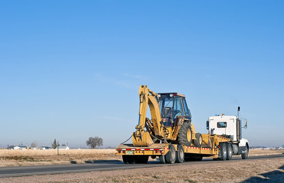 Semi-truck hauling a back-hoe loader combination