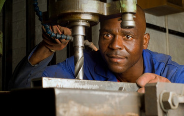 African American with drill press
