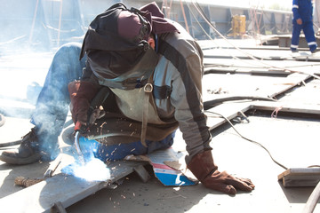 welder with protective mask welding metal and sparks