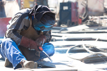 welder with protective mask welding metal and sparks