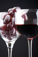 a glass of red wine and grape