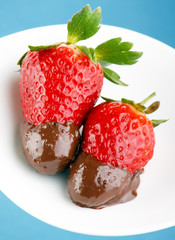 Strawberries dipped in melting dark chocolate.