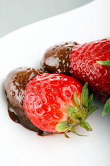 Strawberries dipped in melting dark chocolate.
