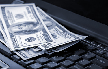 American dollars laying on laptop