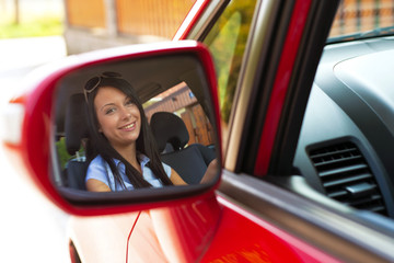 Frau blickt in Außenspiegel bei einem Auto
