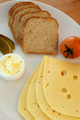 cheese, some bread and tomato on a plate