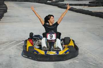happy brunette women wining the karting race - obrazy, fototapety, plakaty