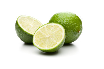 2 Halbe und eine ganze Limette auf weißem Hintergrund