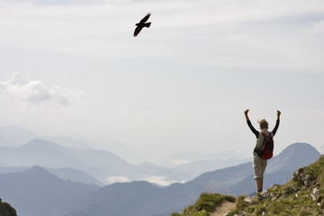 frau mit siegespose in den alpen