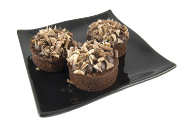 three fancy chocolate cakes on plate isolated on white