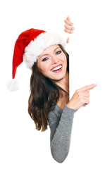 Hübsche Frau mit Weihnachtsmütze präsentiert Textfreiraum