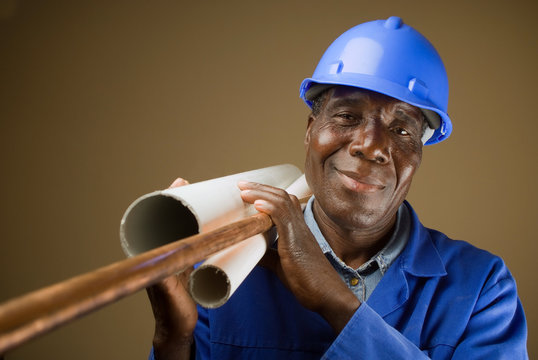 Senior South African or American plumber with pipes