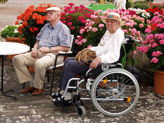 Rentner Paar mit Rollstuhl im Park