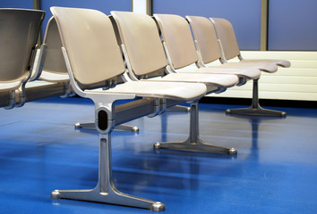 airport lounge with grey seats on blue floor