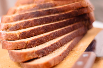 Sliced bread on a wooden cutting board and knife