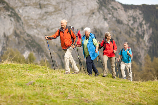 four senior hikers walking in a row