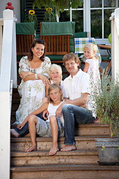 Happy Family Sitting On Garden Steps