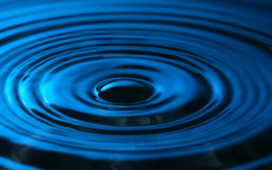 close up of a drop of water in blue colors