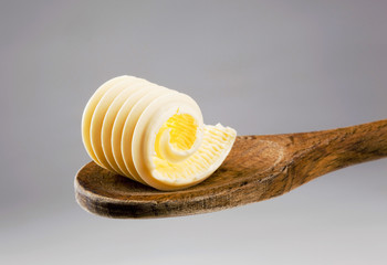 Butter curl on a wooden spoon