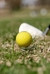 A golf ball and driver with focus on the ball