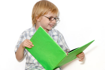 The schoolboy with book in hands on a light background