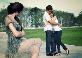Happy young pair in park under a steadfast spiteful sight