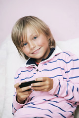 lachender blonder Junge mit Handy