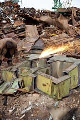 Welder using an acetylene torch to cut through a metal